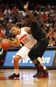 Syracuse guard Brandon Triche dribbles around a defender in the first half.