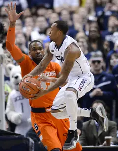 Connecticut guard Ryan Boatright drives through traffic against Syracuse forward James Southerland.