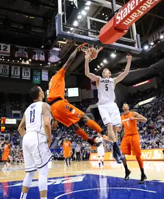 Syracuse small forward throws down a dunk on Connecticut swingman Niels Giffey after stealing an inbounds pass.
