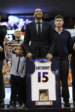 Carmelo Anthony poses with his retired No. 15 jersey.