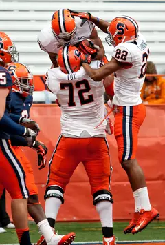 Syracuse guard Ivan Foy lifts running back George Morris II to celebrate one of his touchdowns.