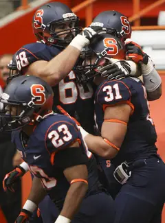 Syracuse fullback Clay Cleveland (31) celebrates with his teammates, including running back Prince-Tyson Gulley (23) and guard Nick Robinson (68).