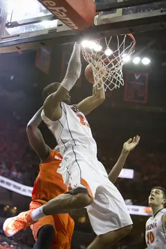 Akil Mitchell,  hangs on the rim after being blocked from behind by Rakeem Christmas.