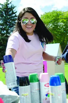 Tatiana Ospina, a sophomore mechanical engineering major, reaches for spray paint to decorate the combined Theta Tau and Alpha Omega Epsilon shack on the quad.  
