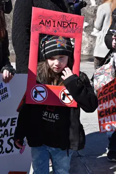 Juliette Clark holds the sign she made in the Syracuse March for Our Lives.