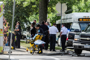 A medical team attends to the injured bicyclist, who had collided with a vehicle on the corner of Comstock and Stratford Tuesday morning.