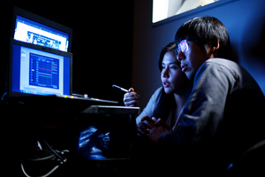 (From left) Yoomin Lee and Chul Min Park, a visiting scholar and a media studies graduate student, respectively, sort out a computer error in a study gauging viewer reaction to presidential debates.