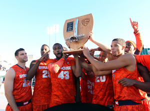 Syracuse celebrates with its trophy for winning the Battle on the Midway Sunday.