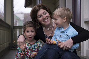 Corrie Raulli sits with her two children on the porch of their home on Livingston Avenue. The Raullis are among the few residents on the street who own the home they live in. The number of owner-occupied homes in the East Neighborhood has declined recently as landlords buy houses to rent to students.