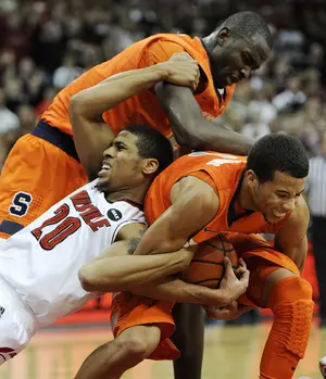 Michael Carter-Williams and Baye Moussa Keita fight for the ball with Louisville forward Wayne Blackshear in Syracuse's 70-68 upset win over Louisville on Saturday. Carter-Williams made a dunk in the final seconds of the game to send the Orange to the victory.