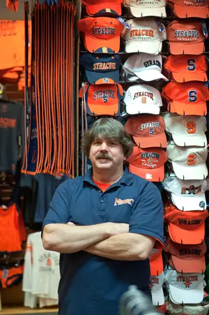 Bill Nester, manager and co-owner of Manny's, prepares for the final Syracuse-Georgetown game at his store on Marshall Street. Local businesses have mixed opinions on the effect the game will have on sales.