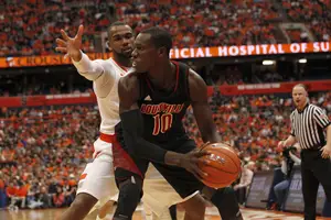 Louisville center Gorgui Dieng looks to pass away from Syracuse forward James Southerland in the Cardinals' 58-53 win over the Orange on Saturday. Dieng finished with 14 points and 11 rebounds.