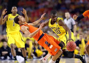 Michigan shooting guard Tim Hardaway, Jr., shoves Syracuse point guard Michael Carter-Williams aside on a drive to the basket.
