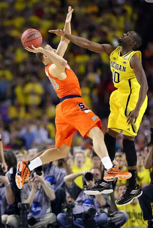 Syracuse guard Brandon Triche struggles to get a shot over Michigan shooting guard Tim Hardaway, Jr., in the Final Four.