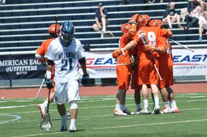 Syracuse celebrates a goal in its 13-9 win over Villanova on Saturday as Wildcats long-stick midfielder John LoCascio walks away. The victory gave the Orange its second straight Big East tournament championship in its final season in the league. 