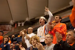 (From left to right) Andrew Schonholtz and Rayhaan Nagrath, recently graudated seniors from Syracuse University, cheer as Syracuse defeats Bryant in first round of the 2013 NCAA tournament.