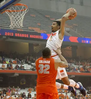 Michael Gbinje throws down in the dunk contest, with a little help from big man DaJuan Coleman. The guard won the dunk contest at Orange Madness over B.J. Johnson, Rakeem Christmas and Ron Patterson.