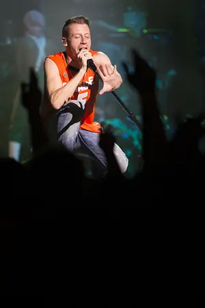 Macklemore sings to a lively crowd in the Carrier Dome while sporting a Syracuse basketball jersey with the his last name featured across the back. The rapper also took the stage in a No. 44 football jersey later on in his performance.  
