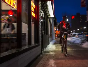 Charlie LaNoue, the Jimmy John’s delivery cyclist, rides past the fast food restaurant on Marshall Street on one of his rides. LaNoue rides on Saturdays, and works from 14 to 16 hours on every shift, where he makes about $300 a night.    