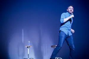 Dan Gurewitch, a College Humor comedian and Syracuse University alumnus, tells a joke on stage at the Goldstein Auditorium during his performance. 