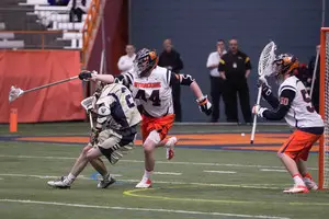 Syracuse long-stick midfielder Matt Harris, playing close defense, bullies a Notre Dame attack. The Syracuse defense was stingy in the team's 11-10 win over the Fighting Irish on Saturday.