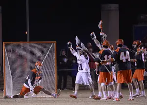 Dominic Lamolinara (left) looks on in a split position as Virginia celebrates a goal in its 17-12 win over the Orange. 