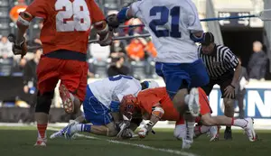Chris Daddio (right) wrestles at the faceoff X with Brendan Fowler (left). Syracuse beat Duke 16-15 on Friday night, and Daddio's faceoff win in the last minute set up the game-winning goal. 