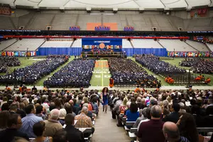 Graduates take their seats in the Carrier Dome during Syracuse University's 160th commencement ceremony.