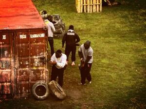 Syracuse players peek around a corner during their paintball game at Fort Drum on Friday.
