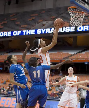 Syracuse forward Briana Day attacks the rim while Central Connecticut State's Kayla Miller (11) and Giocelis Reynoso (15) look on.