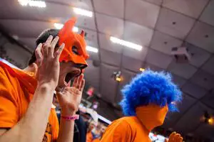 Johnny Oliver, vice president of Otto's Army, wears his orange Batman mask and cape to SU games.