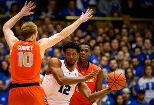Justise Winslow threads a pass in between Trevor Cooney and Tyler Roberson on Saturday night. The Duke small forward tallied 23 points, dismantling the SU zone in a 19-point win for the Blue Devils.