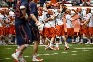 Tim Barber (9) celebrates with Jordan Evans (right) and another teammate after one of Syracuse's 15 goals on Saturday. The Orange rode a well-rounded performance to a six-goal win over No. 5 Virginia.