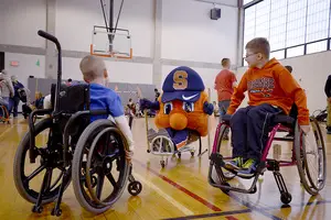 Otto the Orange plays with kids at the OrangeAbility Accessible Athletics Expo on Saturday. The event offered activities such as wheelchair basketball, hand cycles, sled hockey and wheelchair quidditch for both non-disabled people and people with disabilities.