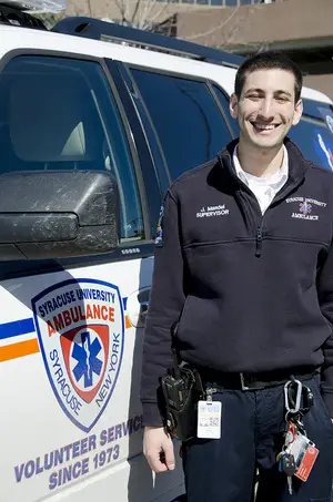Jared Mandel stands in front of his emergency vehicle that he drives as supervisor of Syracuse University Ambulance. He enjoys developing new drivers.