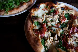 Ironwood’s wood-fired chicken and arugula pizzas feature thick and chewy crust. They’re topped with vegetables and sprinkled with fresh basil and grated parmesan reggiano. The wood fire oven means that the pizza cooks at a higher temperature and caramelizes the toppings. 