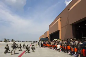 Syracuse players line up outside a Fort Drum aircraft station on Tuesday morning. The team toured the inside and was able to board humvees outside.