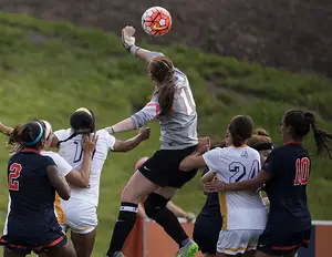 Syracuse goalkeeper Courtney Brosnan leaps above a mob of players to swat away a ball. She collected five saves in SU's 2-1 win.