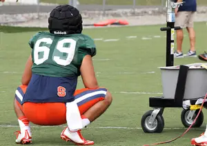 Keith Mitsuuchi squats on the sideline during SU's training camp. The senior walk-on has no in-game experience long snapping.