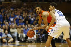 Michael Gbinije fends off a defender during Syracuse's two-point win over Duke on Monday night. He returned to his former school and finished with 14 points.
