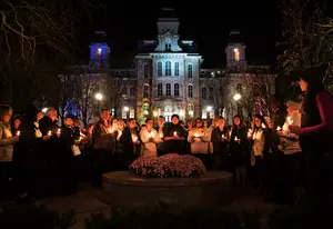 Students observe a moment of silence during a candlelight vigil hosted by Syracuse University’s Remembrance Scholars at the Remembrance Wall after more than 120 people were killed and over 350 wounded during coordinated terrorist attacks across Paris on Nov. 13.