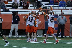 Dylan Donahue (No. 17), Nick Mariano (No. 23) and two other Syracuse players celebrate during the Orange's 9-8 win against Army. 