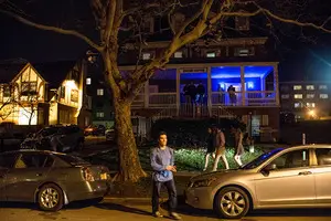 People congregate outside of Zeta Beta Tau Fraternity house on campus for a party. 
