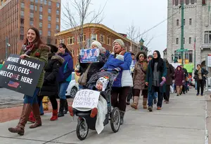 Demonstrators protesting Trump's immigration policies took to the streets of Syracuse on the anniversary of the travel ban. 
