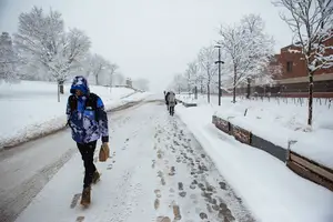 Zach Minkin, a freshman in the Martin J. Whitman School of Management, walks down the Syracuse University promenade Friday morning after SU announced that classes were canceled.