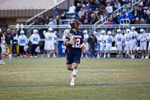 Jamie Trimboli carries the ball. On his left leg he wears a band in honor a or former teammate who suffered an injury on the lacrosse field which lead to his death four days later.