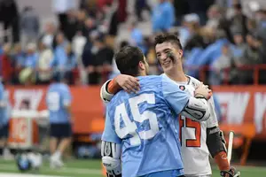 Brendan Bomberry and Chris Cloutier embrace after Syracuse beat North Carolina 13-12 in overtime. The No. 45 has a special meaning for the two former The Hill Academy players, celebrating the life of a former Hill Academy player who collapsed on the field and died. 