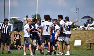 Bishop Grimes' running back Tyler Wait (left) speaks with his teammates at an offseason scrimmage. Others in the huddle include AJ Burnett, Jr. (No. 7) and Nate Gay (No. 81).