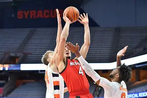 Buddy Boeheim and Alan Griffin both reach for the ball from NC State's Jericole Hellems.