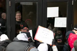 A DPS officer in plain clothes blocks protestors from entering Crouse-Hinds Hall during #NotAgainSU's 31-day occupation of the building last February and March. Lynch's review recommends that DPS abandon dispatching officers in civilian clothes to future protests. 